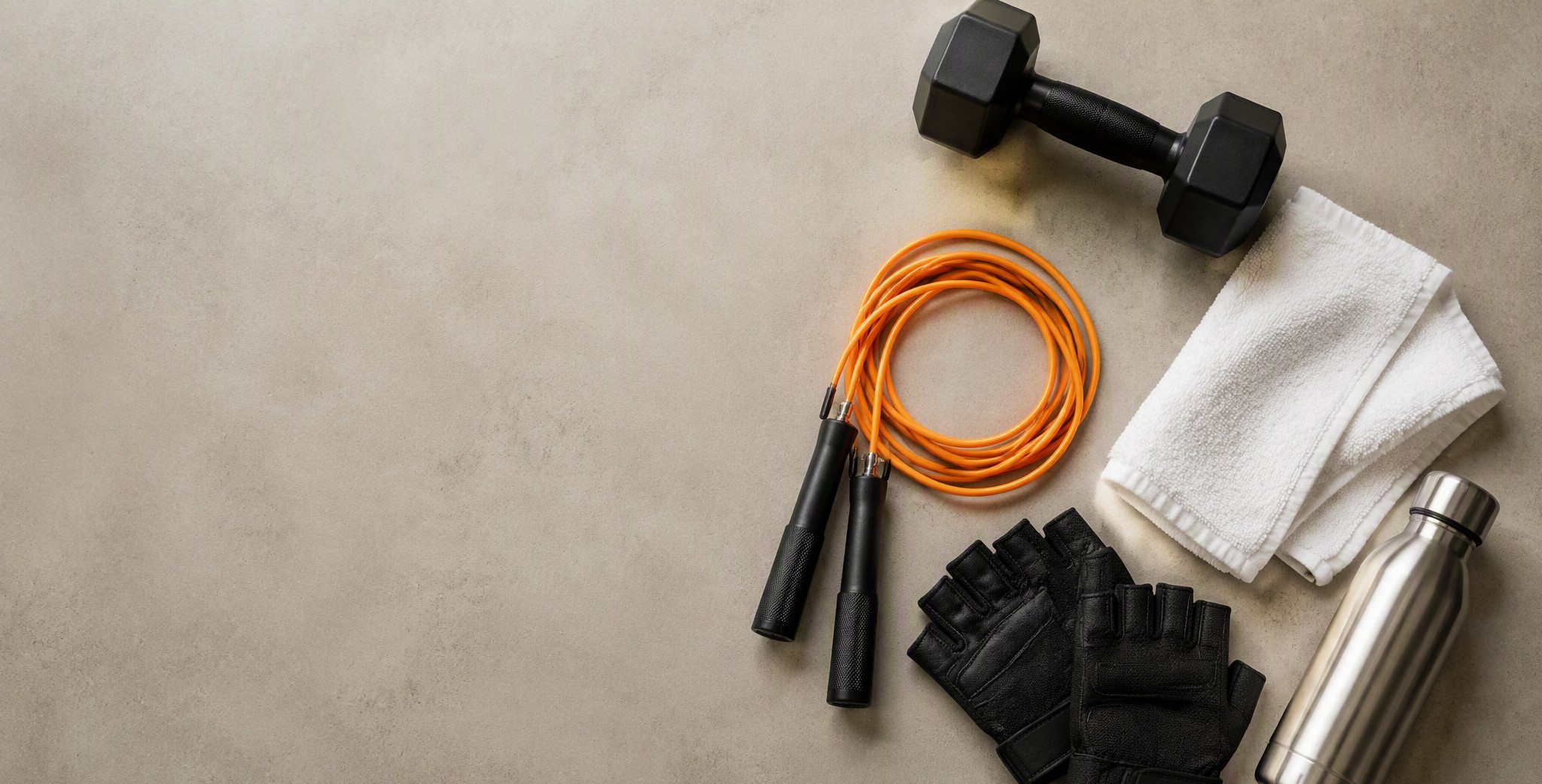Training gear flat lay — dumbbell, rope, gloves